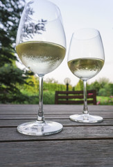 white wine glasses on wooden table at garden