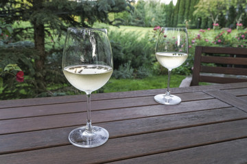 white wine glasses on wooden table at garden
