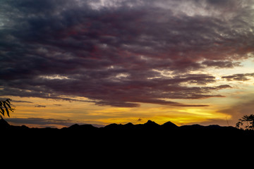 The ridge is a black silhouette. Sunset time. Use as background.