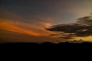 The ridge is a black silhouette. Sunset time. Use as background.