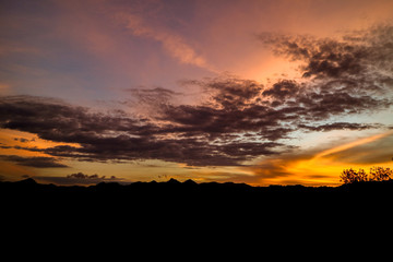 The ridge is a black silhouette. Sunset time. Use as background.