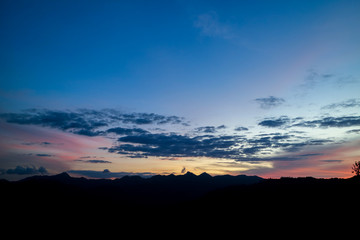 The ridge is a black silhouette. Sunset time. Use as background.