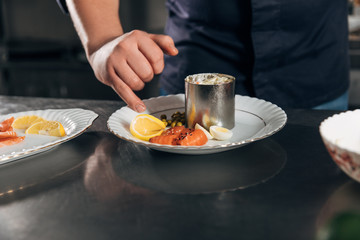 cropped shot of chef preparing salad at restaurant
