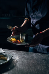 cropped shot of chef preparing salad with metal forming tube