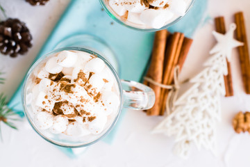 Hot cocoa with marshmallow and ground cinnamon in glasses on the table in Christmas decorations. Top view