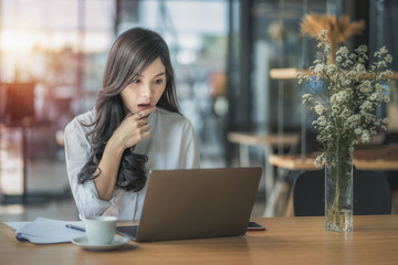 Young business woman using on the laptop while sitting at her working place.	