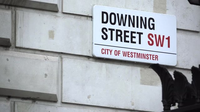 People walking by the Downing Street sign