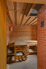 Obraz na płótnie Canvas A steam room with wooden plank beds and a brick wall