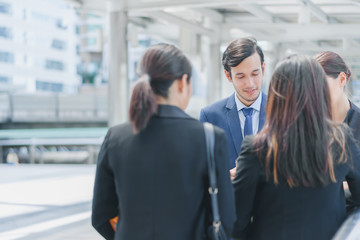 Professional business team standing outside discuss new project in cityscape background