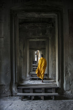 Rear view of monk walking in Angkor Wat