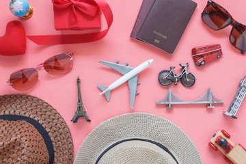 Flat lay image of accessory clothing women to plan travel in valentine's day background concept.Passport & clothes with many essential  items in holiday season.Several objects on  modern pink paper.