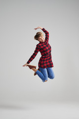 Young woman jumping in the air happily at studio