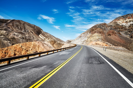 Empty highway in deserted mountainous terrain, travel concept, USA.