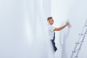 Handyman cleaning white wall