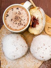 Classic donuts with powdered sugar, on wooden background
