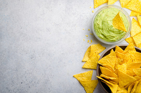 Traditional mexican homemade guacamole sauce in a glass bowl and