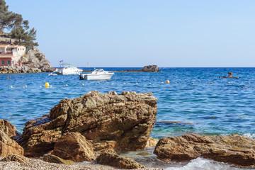 Fototapeta na wymiar rocky sea shore with pebble beach, waves , blue sky