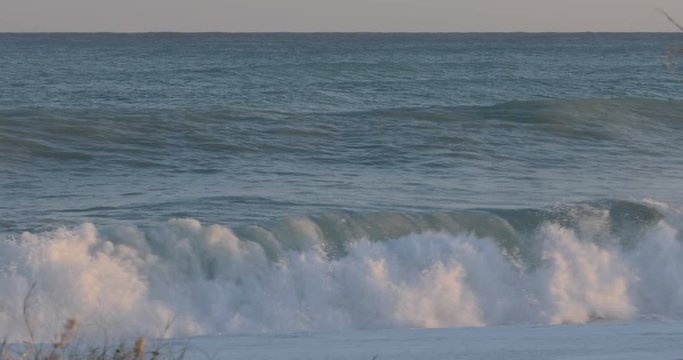Oceano e mare mosso in tempesta con onde impetuose che si infrangono sulla spiaggia.
