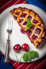 Homemade cherry pie on blue table.