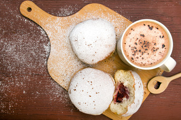 Classic donuts with powdered sugar, on wooden background