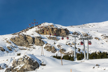 Red gondolas in ski resort Serfaus Fiss Ladis in Austria with snowy mountains