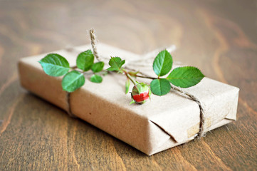 Gift box wrapped in recycled brown paper decorated with red rose