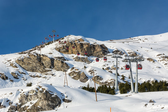 Red gondolas in ski resort Serfaus Fiss Ladis in Austria with snowy mountains