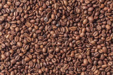 Background with organic spilled arabica coffee in beans