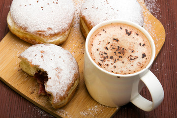 Classic donuts with powdered sugar, on wooden background