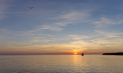A view of the calm golden sunset on the river with the sun reflected in it, Volga, Russia