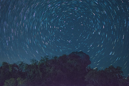 Star trail at Pha Hua Sing mountain in the night, The name of lion face rock in Thai language at Doi Samer Dao national park - Thailand