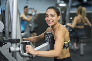 training woman, Young strong woman training at gym machines