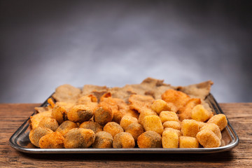 Italian food. Fried meat, cream and olives ascolane . Typical regional dish. Wooden table, black background