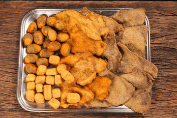 Raw handmade italian pasta tagliatelle on a wooden table. Black background