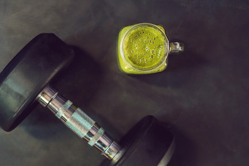 green smoothies and dumbbells in the gym