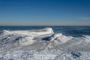Ice formations on beach with blue water