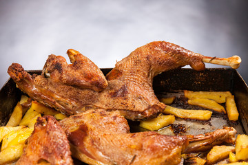 Roast chicken with potatoes. Black background. Porn food