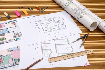 Fototapeta premium plan of apartment rooms and blueprint rolls with work tolls