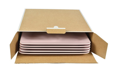Open cardboard box with a stack of square pink plates, isolated on white