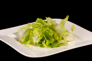 Salad with pumpkin oil on a black background