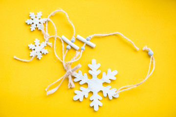 white wood snow flake on yellow paper background