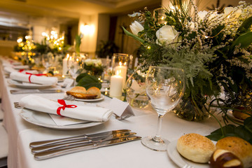 white table set for party with flowers, candle and bulbs