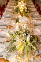 white table set for party with flowers, candle and bulbs