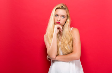 Young woman in a thoughtful pose on a solid background