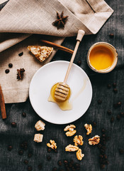 beautiful layout: honey, honey stick and nuts on a gray napkin