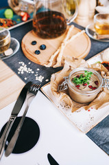 a beautiful layout of food for breakfast: a jar with pate and Pomegranate seeds, Italian sticks of grissini and a cup of tea