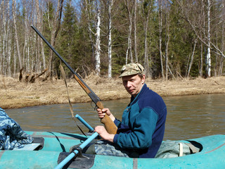 Hunter with a gun in an inflatable boat