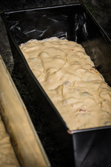 Cake batter and dough in a black baking form ready to be placed in an oven in a modern home kitchen. - 186578376