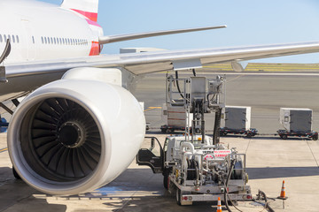 Truck parked under an aircraft wing refuelling