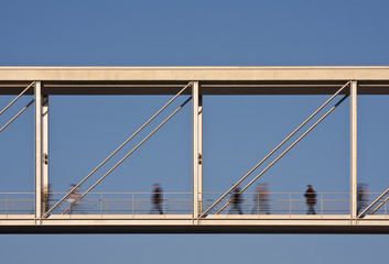 Motion Blurred People Crossing A Bridge